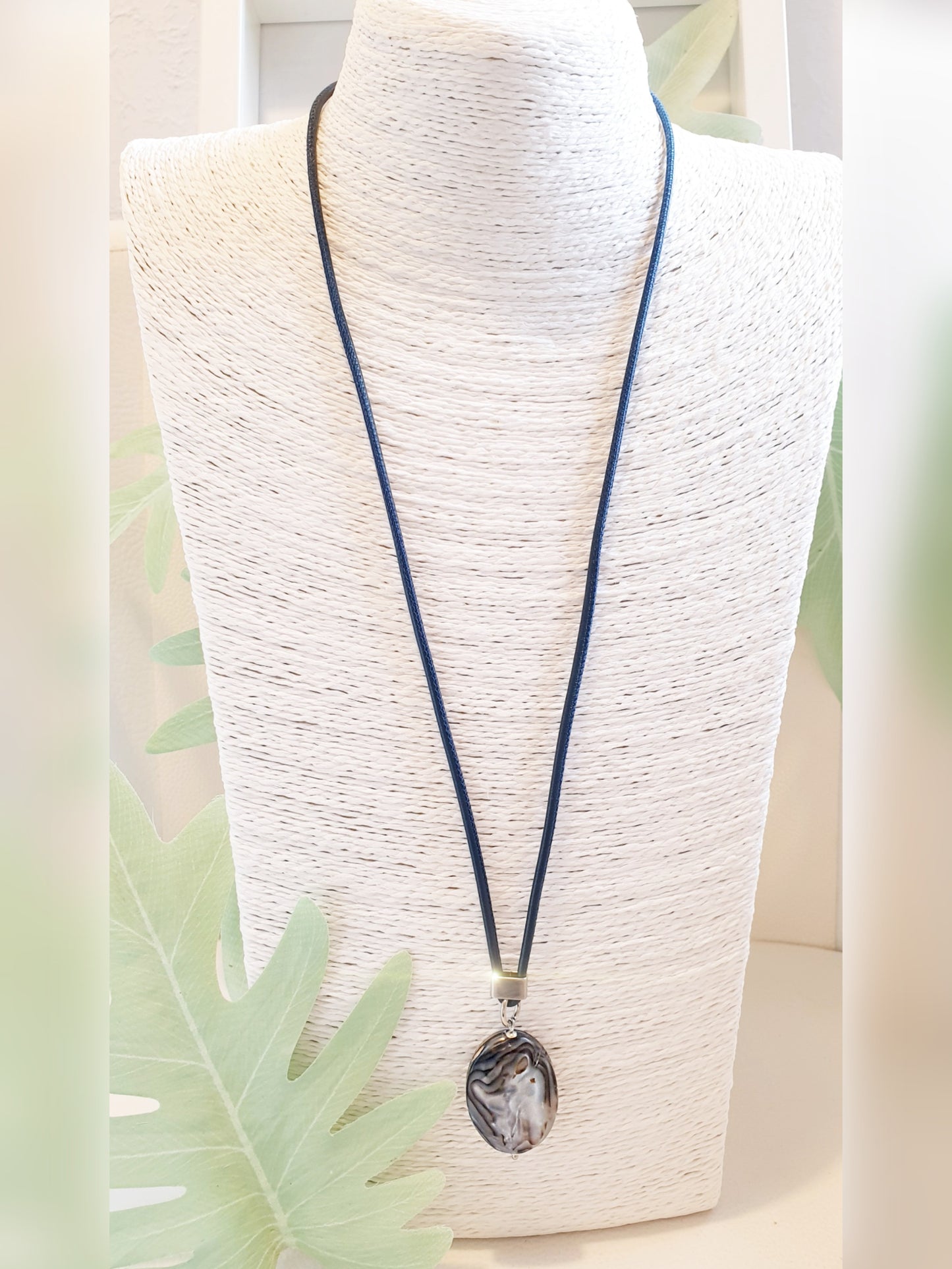 Lange, blaue Lederkette mit ovalem Anhänger aus blau grauem Perlmutt