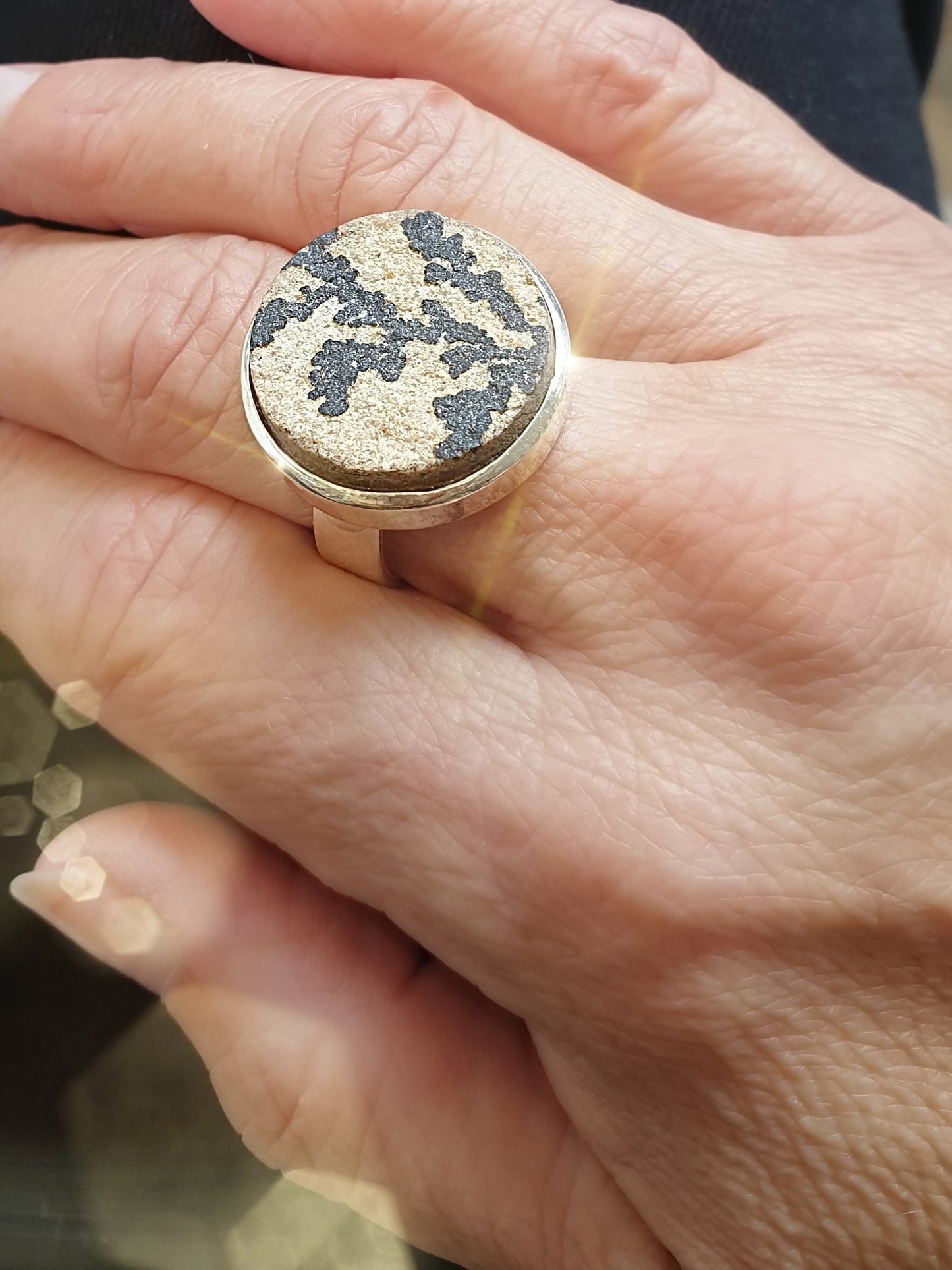 Silberring mit großem rundem Stein mit fossiler Pflanze an Hand