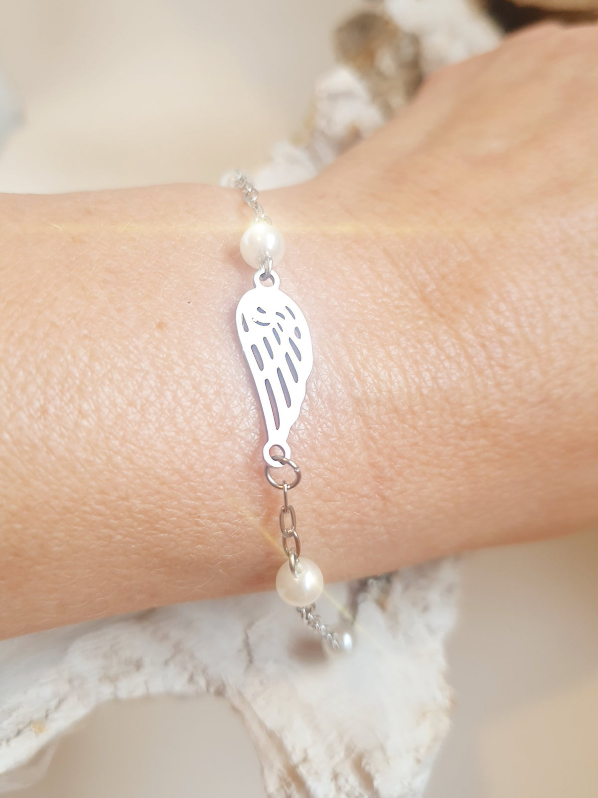 Zartes Armband aus Edelstahl mit Engelsflügel und kleinen Perlen