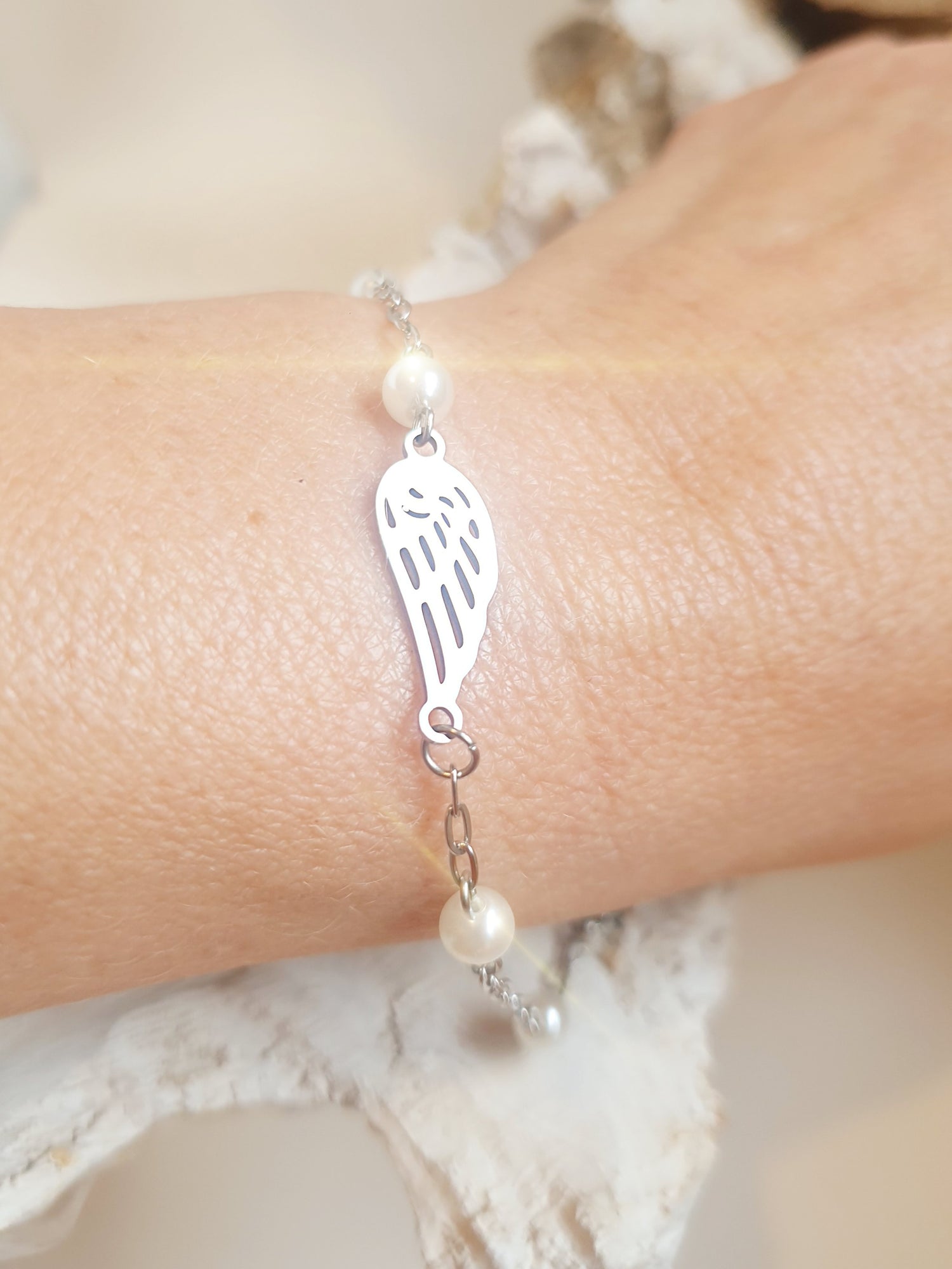 Zartes Armband aus Edelstahl mit Engelsflügel und kleinen Perlen