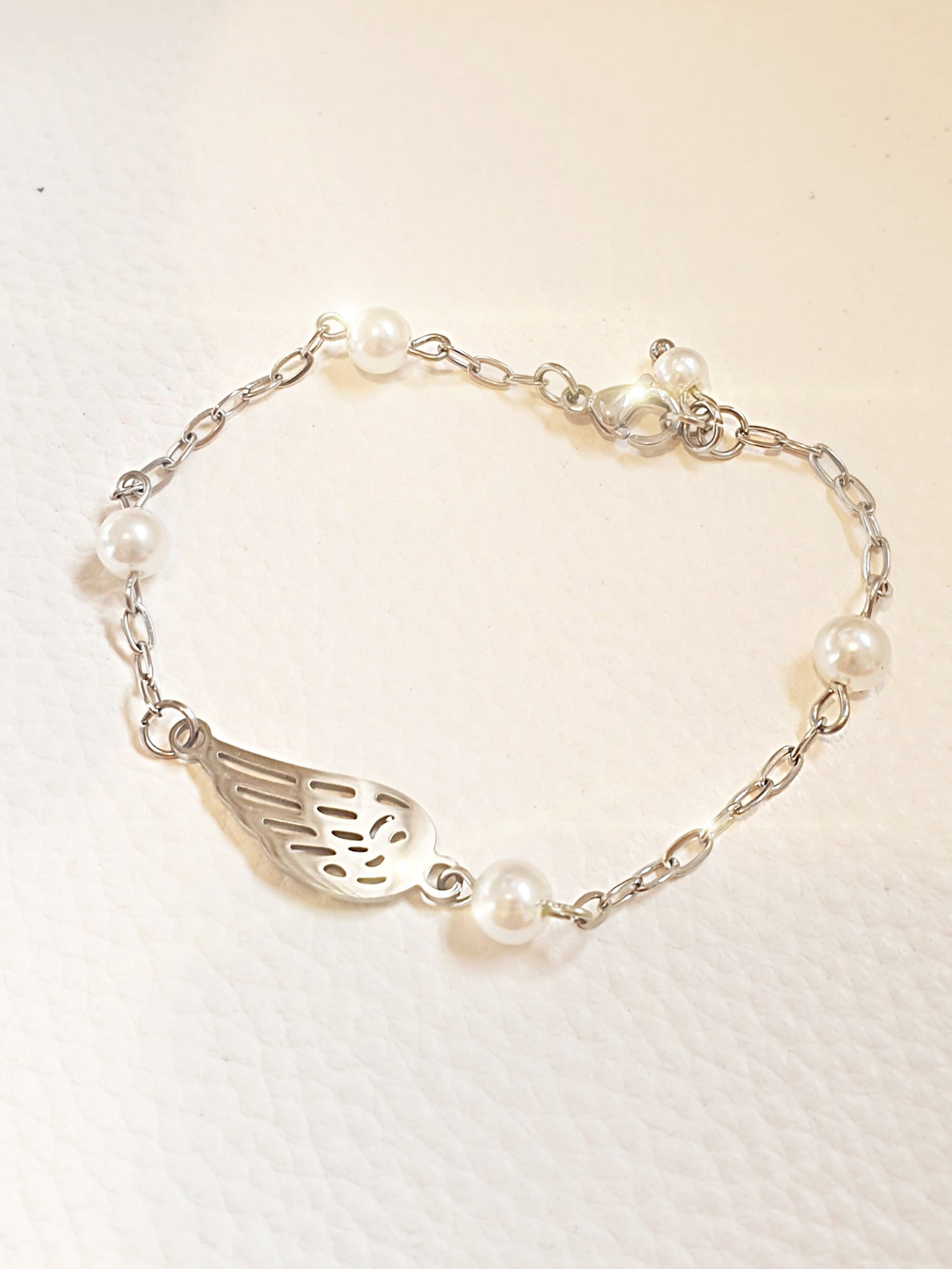 Zartes Armband aus Edelstahl mit Engelsflügel und kleinen Perlen