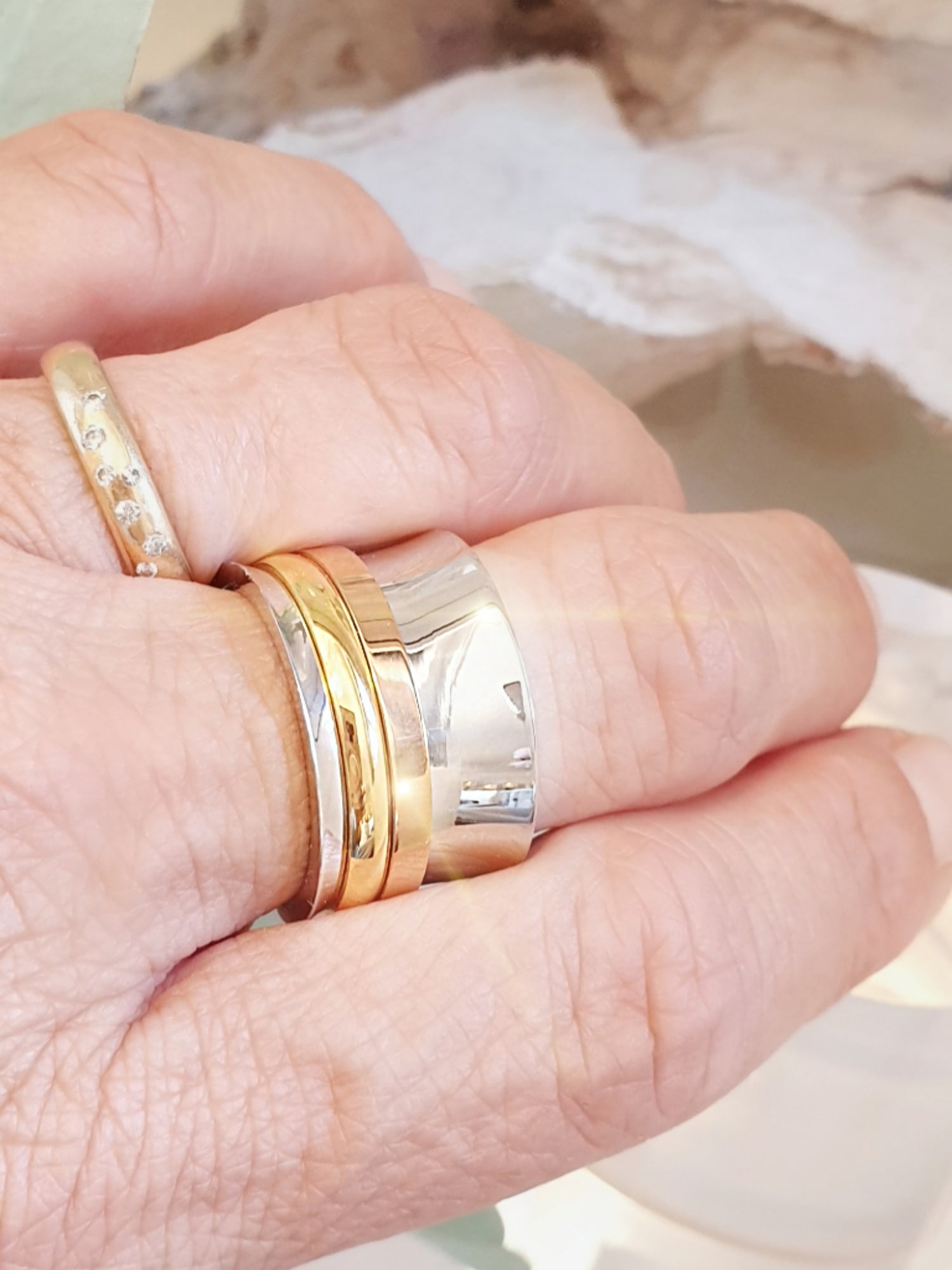 Breiter Edelstahlring in Silber mit Spielringen in Roségold und Gelbgold